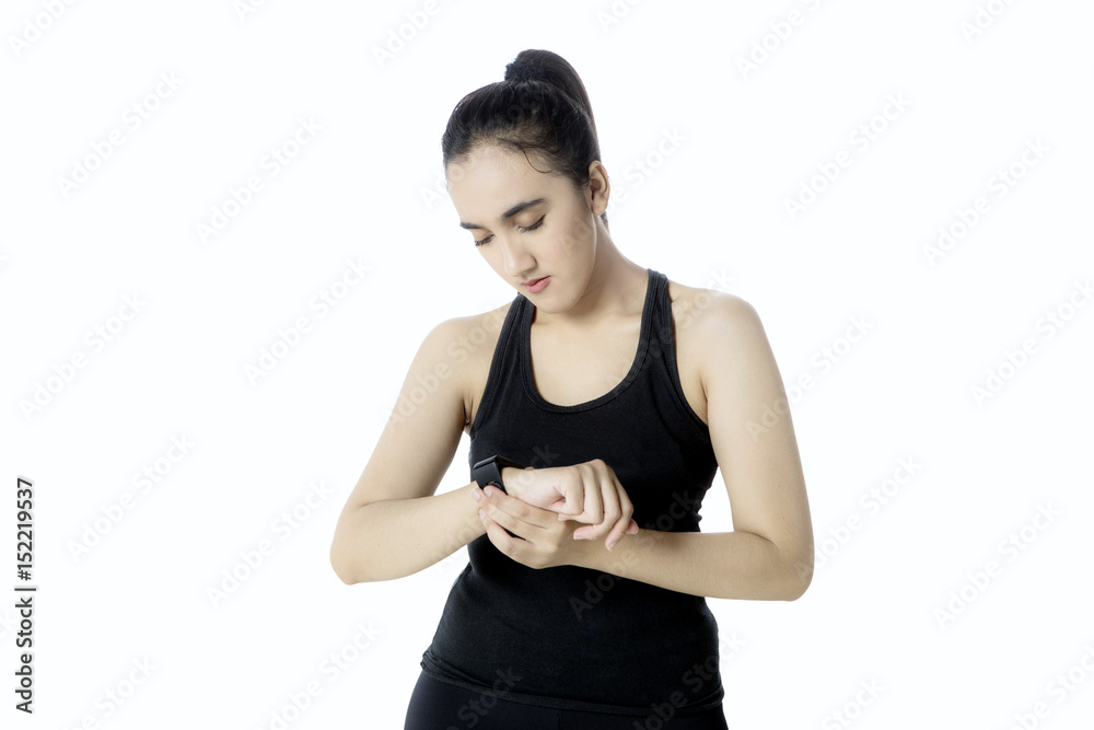 Young woman setting up her wristwatch Young woman setting up her wristwatch