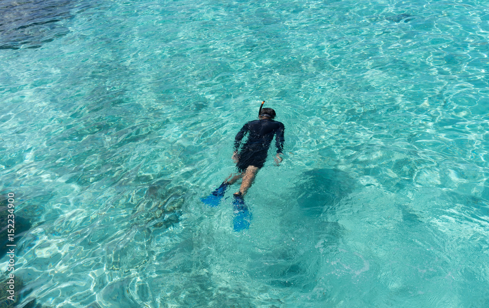 Young woman snorkeling in tropical water