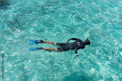 Young woman snorkeling in tropical water