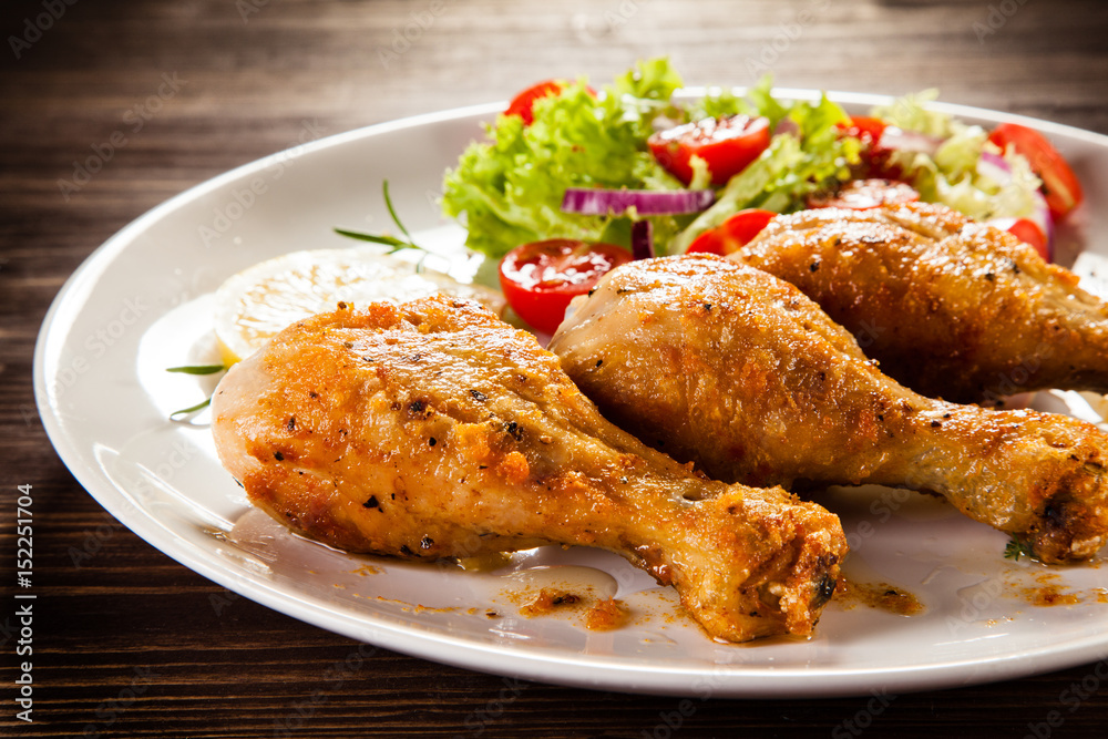Grilled chicken drumstick on wooden table Grilled chicken drumstick on wooden table