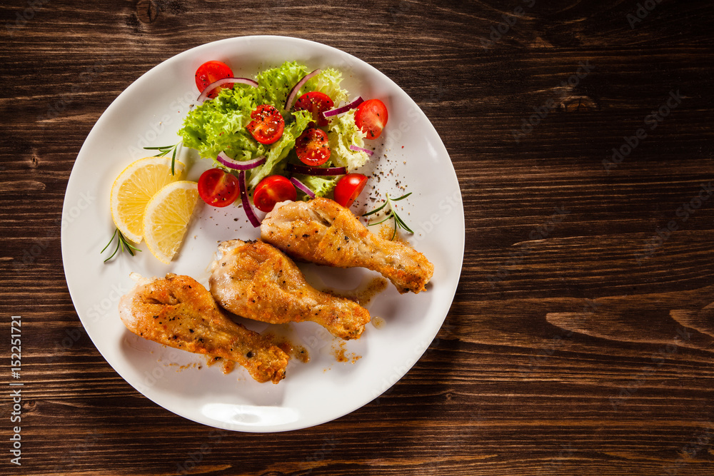 Grilled chicken drumstick on wooden table Grilled chicken drumstick on wooden table