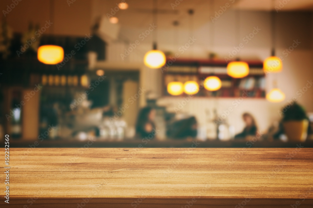 wooden table in front of abstract blurred restaurant lights background
