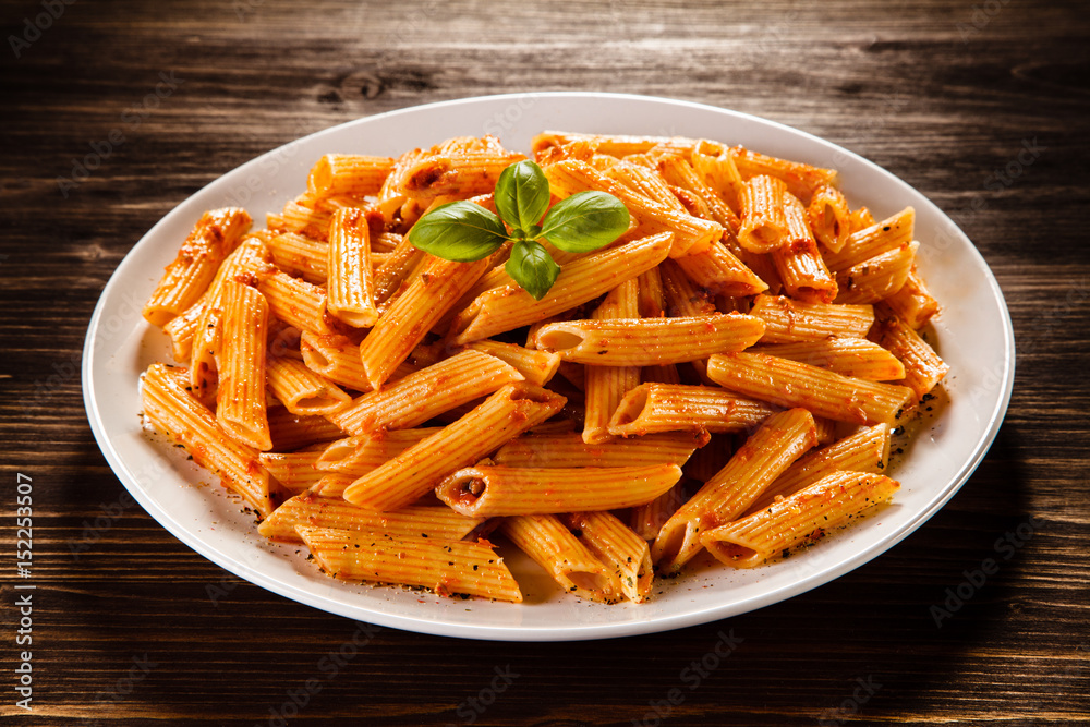 Pasta with tomato sauce on wooden table