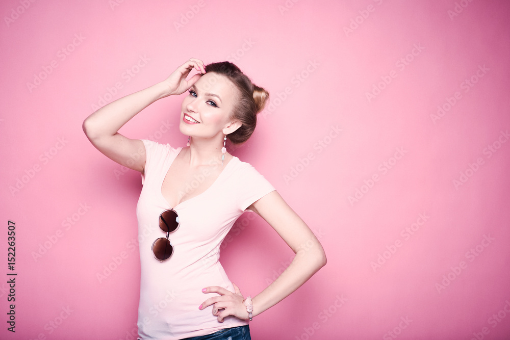 close-up portrait of young beautiful slim sexy young blonde woman in a retro pin-up style on pink background in studio wearing sunglasses smiling and posing close-up portrait of young beautiful slim sexy young blonde woman in a retro pin-up style on pink background in studio wearing sunglasses smiling and posing