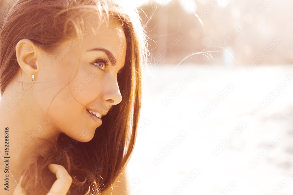close-up portrait of a beautiful young brunette in sunglasses girl on a sunny day in the summer on the beach by the sea smiling at sunset in denim shorts and top with print US flag lifestyle close-up portrait of a beautiful young brunette in sunglasses girl on a sunny day in the summer on the beach by the sea smiling at sunset in denim shorts and top with print US flag lifestyle