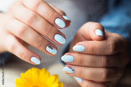 beautiful manicure. Gel polish coating in blue, embossing. photo
