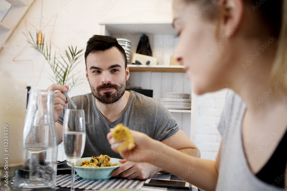 Young couple sitting at the table and eating dinner