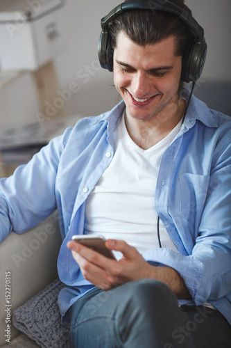 Handsome guy listening to music on internet with smartphone photo