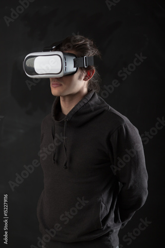 man standing in virtual reality helmet before dark background © chesterF