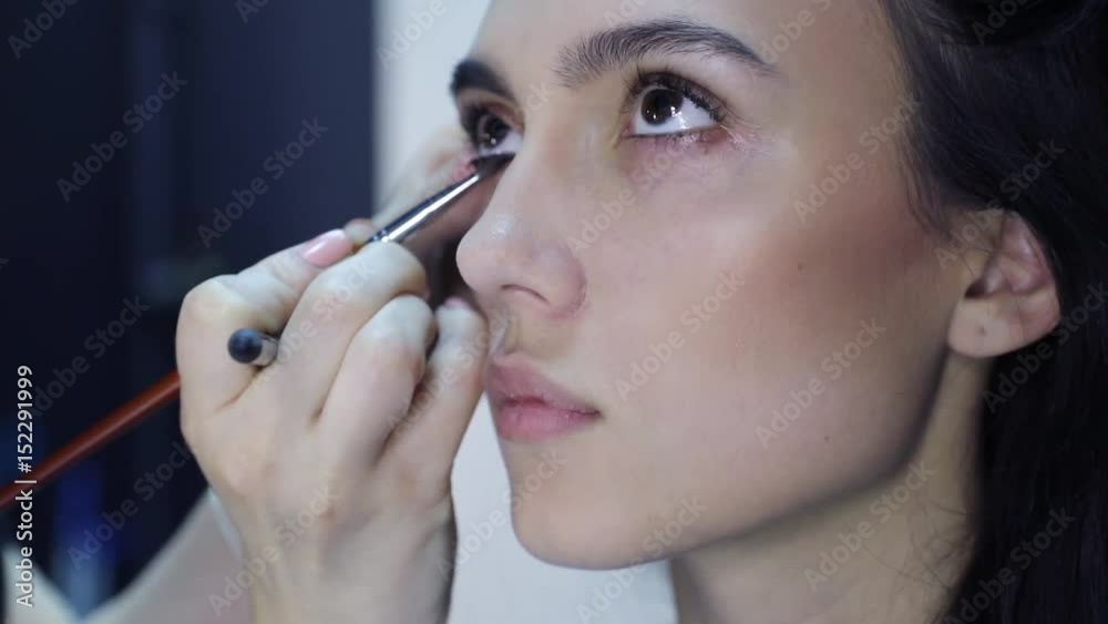 make up artist doing professional make up and working with young beautiful woman make up artist doing professional make up and working with young beautiful woman