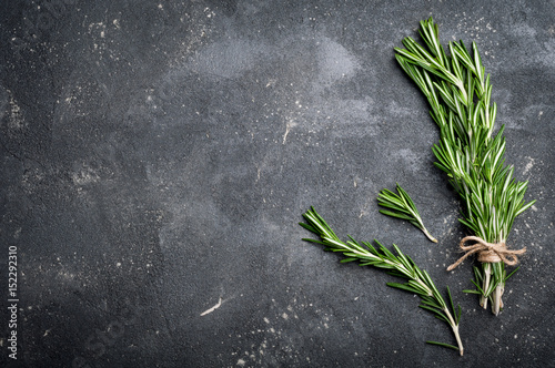 Rosemary on dark concrete table top view. Herbs and spices background. Copy space for your recipe