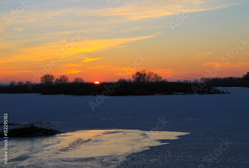Sunset over a frozen river Dnieper on winter