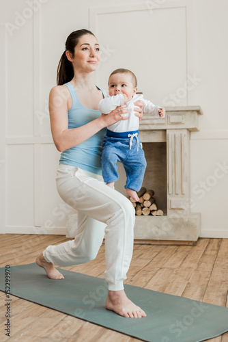 Mother with baby boy practicing yoga on yoga mat at home