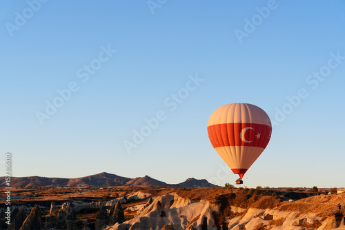 Hot air balloon flying over valley at sunrise. Cappadocia. Turkey