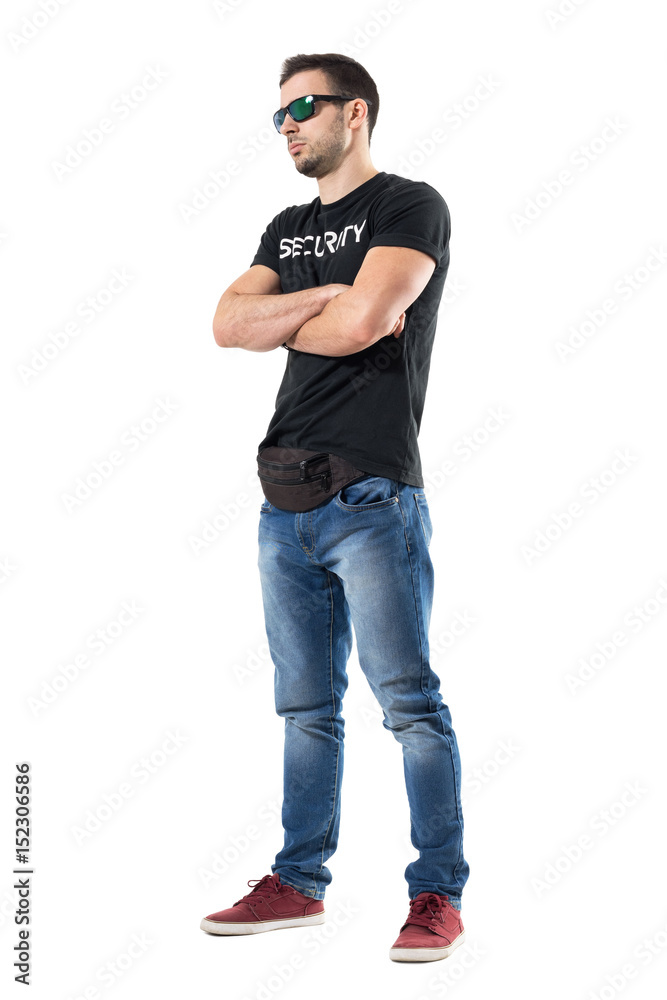 Serious tough macho undercover cop or bouncer with crossed arms looking away. Full body length portrait isolated on white studio background. Serious tough macho undercover cop or bouncer with crossed arms looking away. Full body length portrait isolated on white studio background.