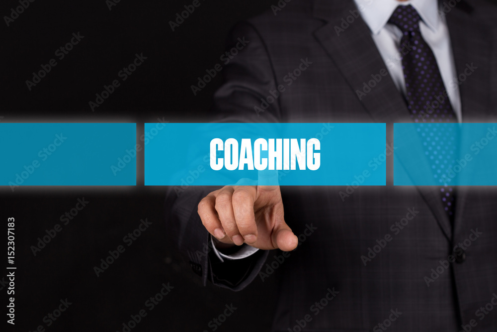 Hand pushing on a touch screen interface-COACHING button Hand pushing on a touch screen interface-COACHING button
