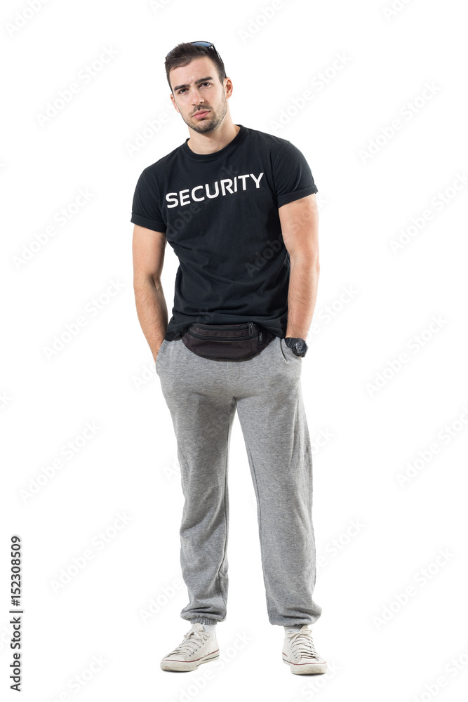 Skeptical young bouncer with hands in pockets frowning and looking at camera. Full body length portrait isolated on white studio background. Skeptical young bouncer with hands in pockets frowning and looking at camera. Full body length portrait isolated on white studio background.