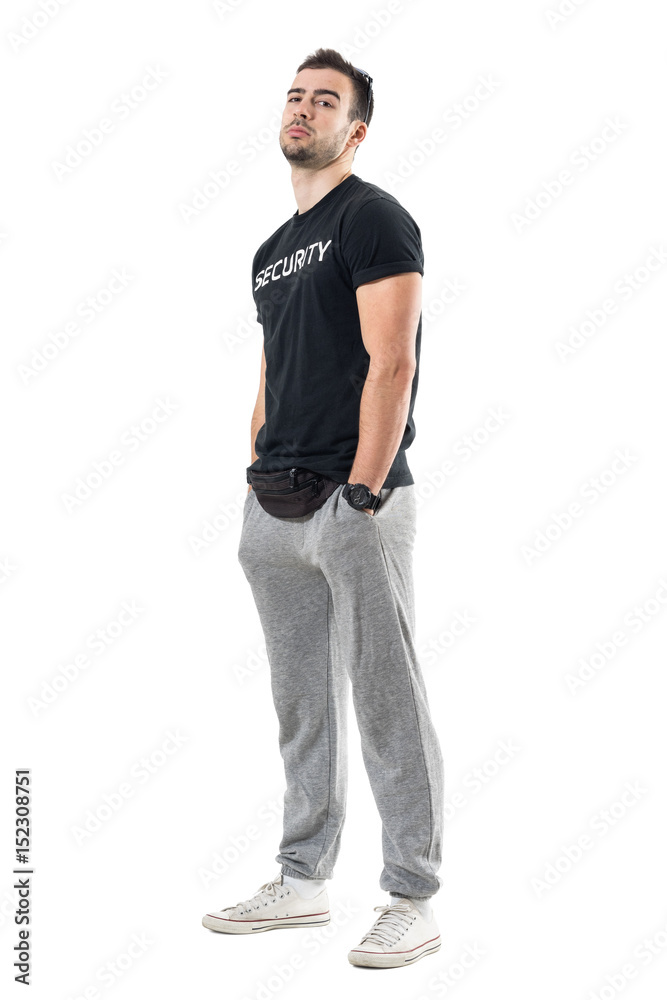 Side view of young macho bouncer with hands in pocket and head tilted back. Full body length portrait isolated on white studio background. Side view of young macho bouncer with hands in pocket and head tilted back. Full body length portrait isolated on white studio background.