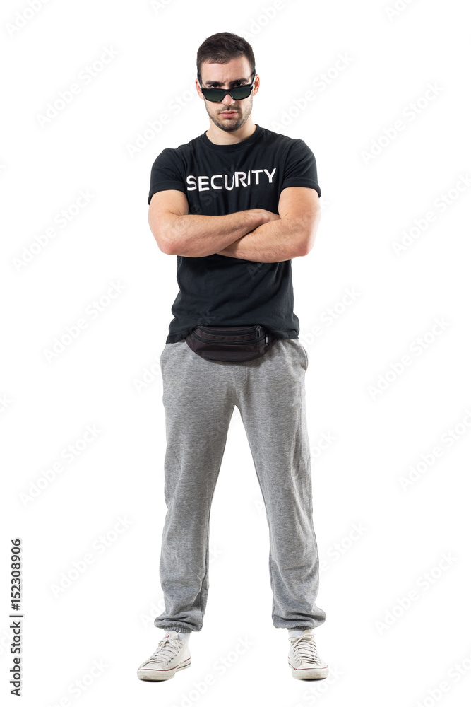 Tough serious bouncer or bodyguard with crossed arms staring at camera. Full body length portrait isolated on white studio background. Tough serious bouncer or bodyguard with crossed arms staring at camera. Full body length portrait isolated on white studio background.