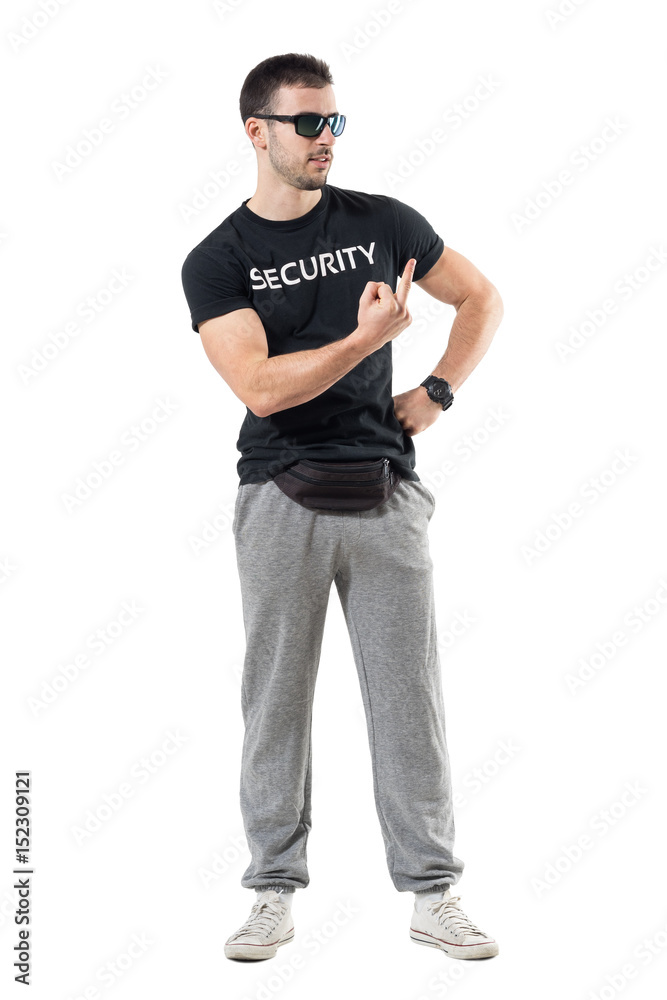 Rude bouncer in sportswear with waist bag showing middle finger looking away. Full body length portrait isolated on white studio background. Rude bouncer in sportswear with waist bag showing middle finger looking away. Full body length portrait isolated on white studio background.
