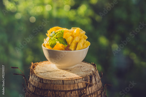 pieces of pineapple on a background of greenery photo