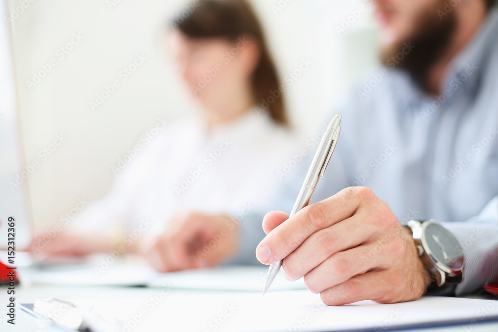 A businessman is holding a pen in his hand. Put a signature. Image with depth of field. A businessman is holding a pen in his hand. Put a signature. Image with depth of field.