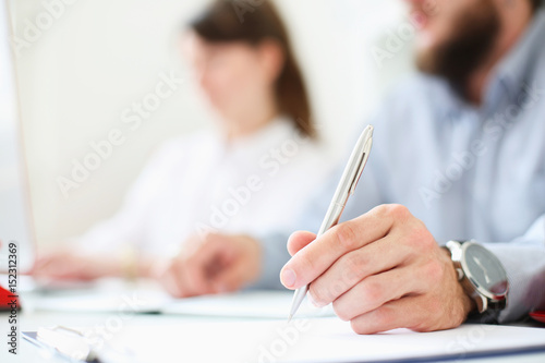 A businessman is holding a pen in his hand. Put a signature. Image with depth of field.
