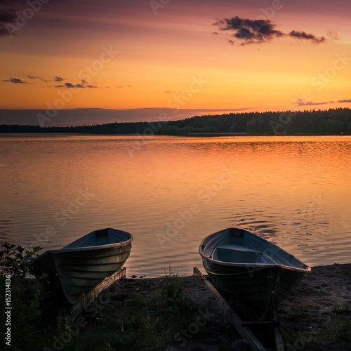 Landscape with lake, boats and sunset at summer evening in Finland