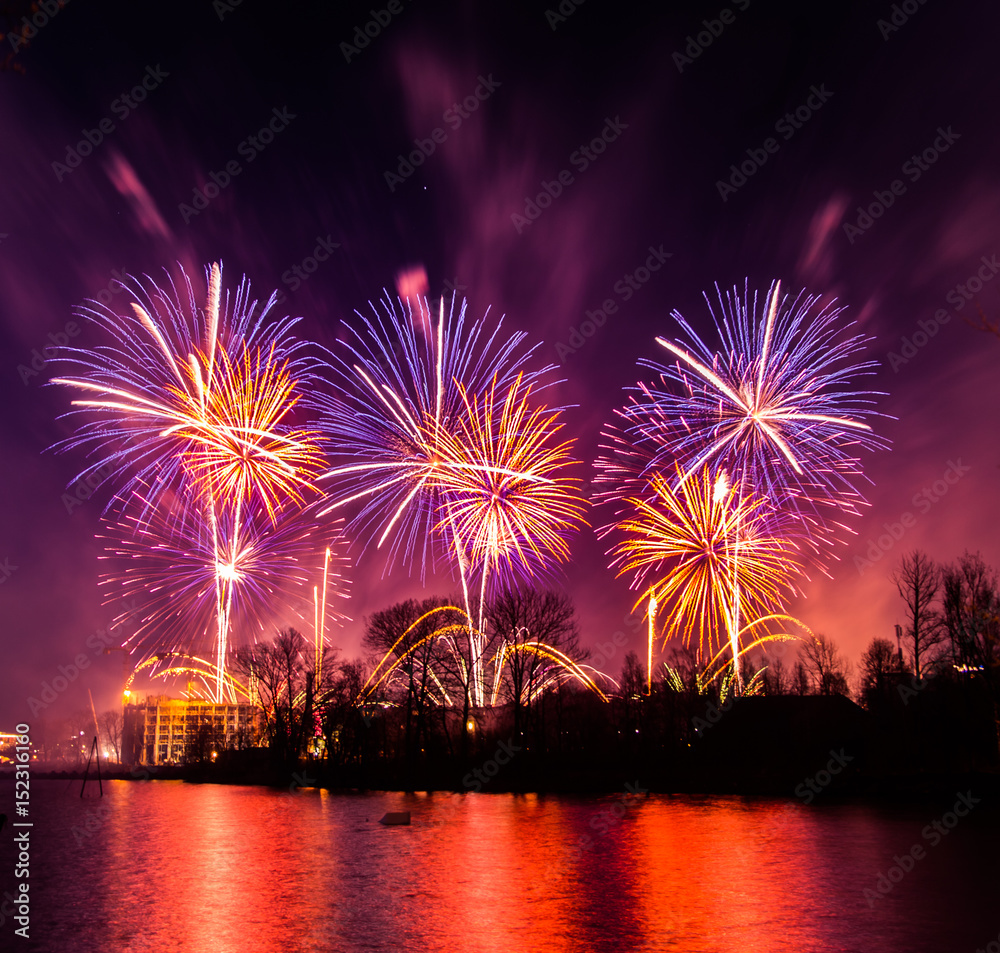 Beautiful, colorful fireworks above the river during an Independence day in Riga, Latvia.