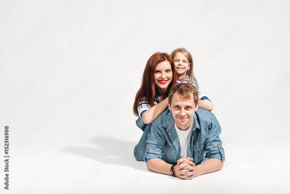Happy funny family portrait lying on white background isolated on father's back