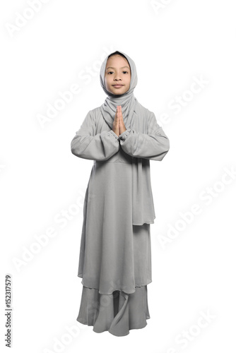 Smiling asian muslim kid with traditional dress standing