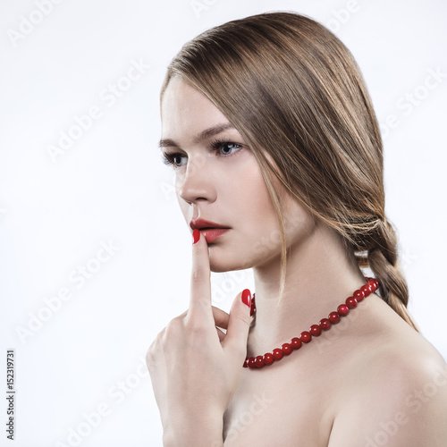 A model with naked shoulders and a red necklace. 