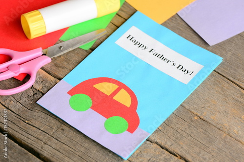 Happy Father's day greeting card. Colored paper sheets, scissors, glue on old wooden background. Creative Father's day cards for kids to make. Kids paper crafts idea. Closeup