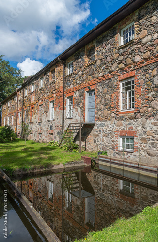 Huge stone mansion house facade on river. Dobele, Latvia. Travel inspiration. Postcard concept.