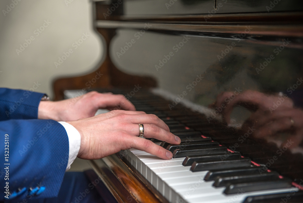 Young man hands playing on piano (shallow DOF)