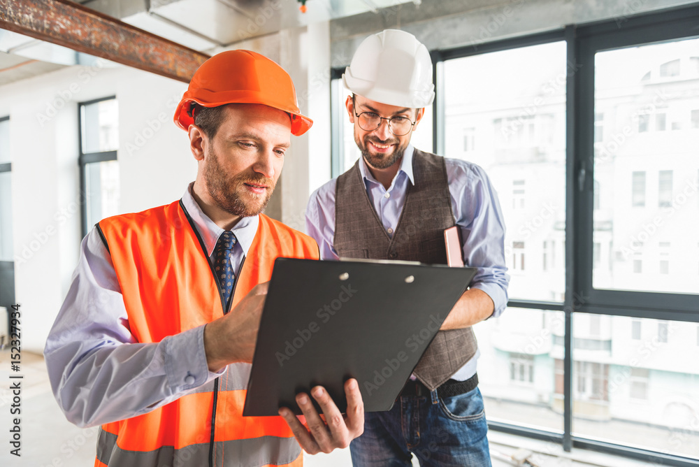 Busy constructors standing in room Busy constructors standing in room
