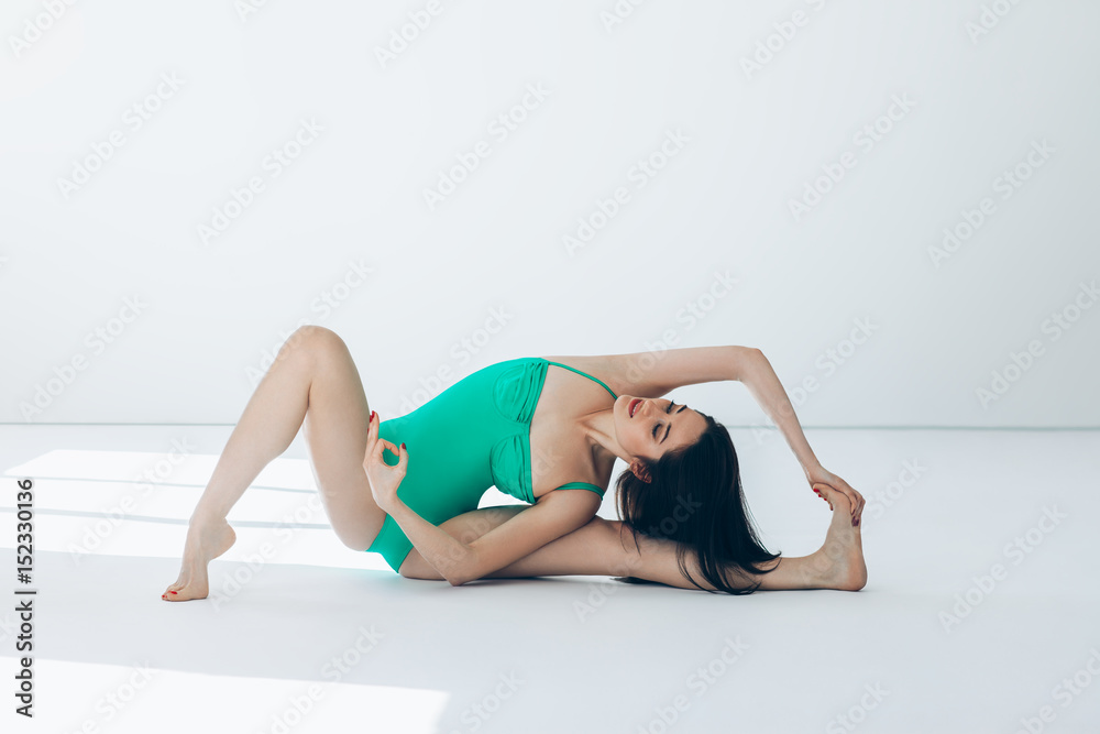 Young beautiful woman doing yoga asana revolved head to knee pose