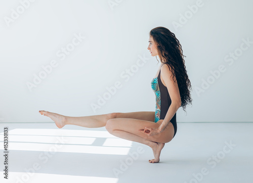 Young beautiful woman doing yoga asana tiptoe pose photo