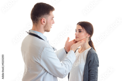 a young doctor in the smock stands opposite the female and holds her face