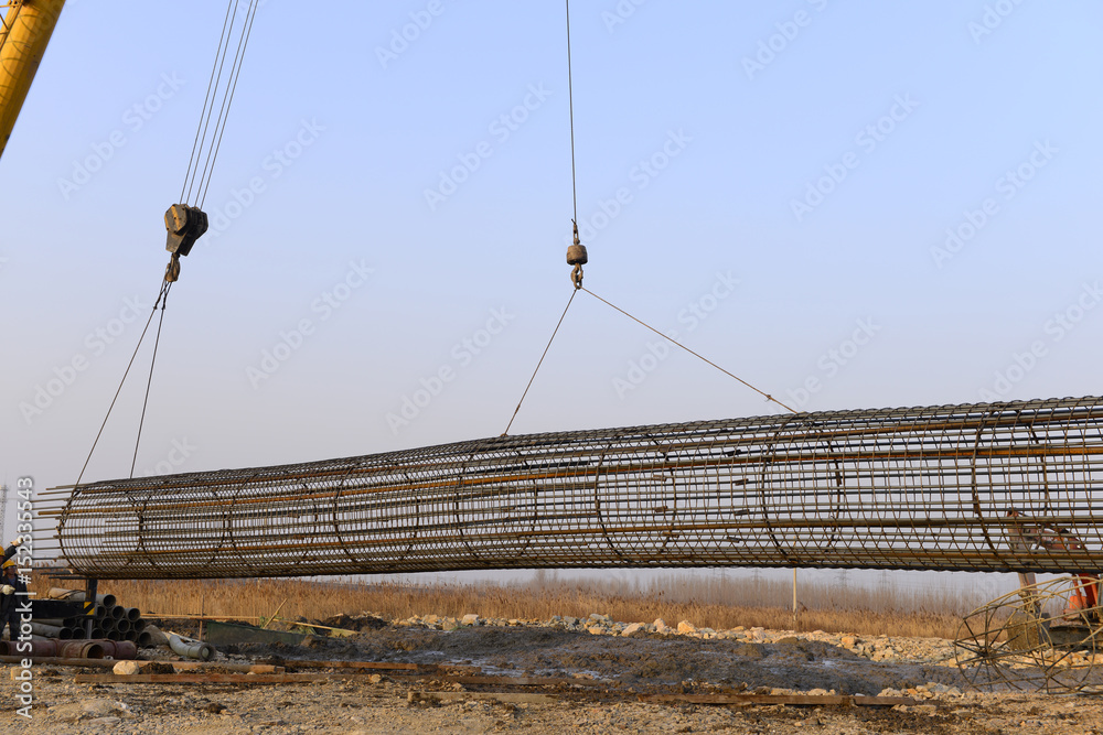 Fototapeta premium Hoisting steel bars in the construction site