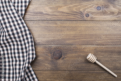 Background of plaid kitchen tablecloth and cookware on wooden background. Copy space. Horizontal shoot.