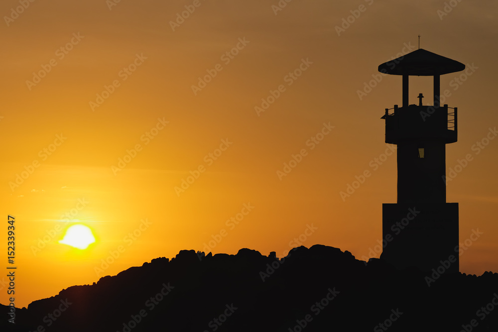 Photo of the night silhouette of the lighthouse in a bright orange sunset sky, Nang Thong Beach, Khao Lak, Thailand