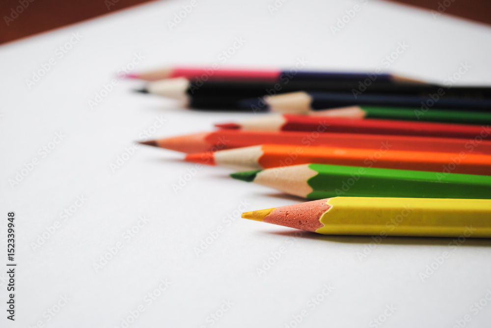 Colored pencils and a piece of paper Colored pencils and a piece of paper