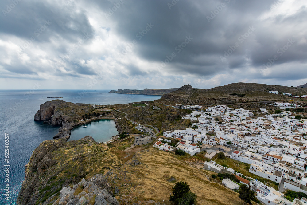 Cityscape of Lindos and view of St Paul's Bay on a cloudy day, view from the Lindos castle, Rhodes island, Greece