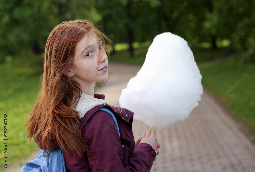 Girl eating sweet cotton candy in the park Girl eating sweet cotton candy in the park