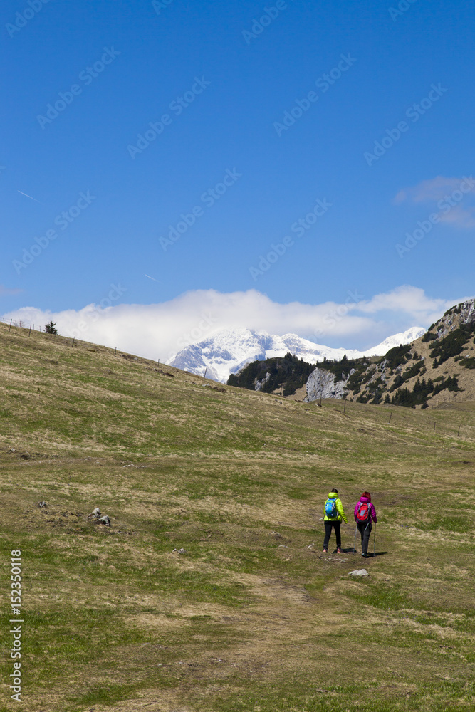 Hikers walking on hike in mountain nature landscape in Slovenian Alps. Hiking – sporty hiker woman on trek with backpack living healthy active lifestyle