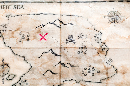 Close up to Vintage folded fake map with red cross of Pirates Treasure chest