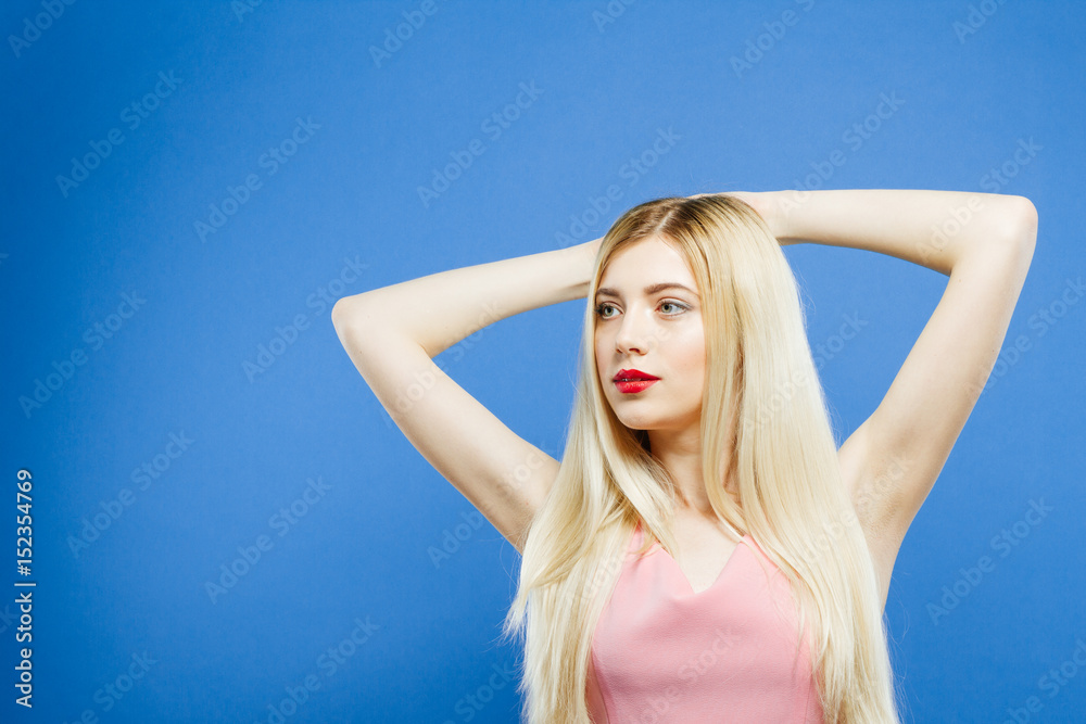 Portrait of Sensual Blonde with Red Lips on Blue Background. Cute Girl is Posing in Studio. Portrait of Sensual Blonde with Red Lips on Blue Background. Cute Girl is Posing in Studio.