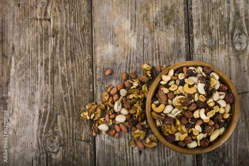 Nuts in a wooden bowl on a wooden table.