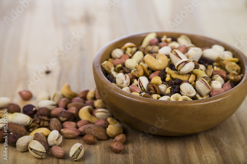 Nuts in a wooden bowl on a wooden table.